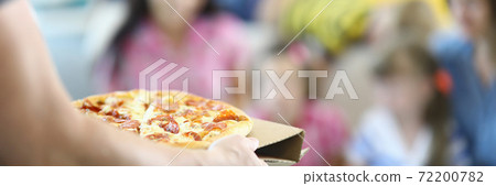 Male hands carry pizza on cardboard stand close up. Male hands carry pizza on cardboard stand close up. 72200782