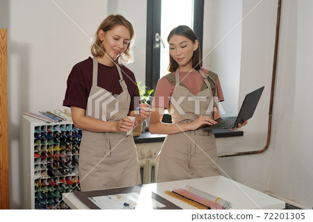 Happy young blond female putting handmade glass beads into small linen sack Happy young blond female putting handmade glass beads into small linen sack 72201305