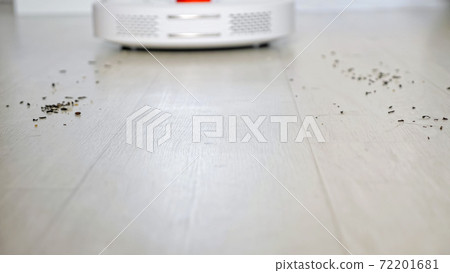 Robot vacuum cleaner with red lamp drives to scattered trash 72201681