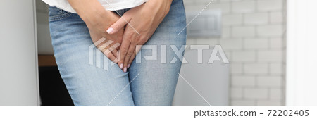 Female hands between legs in jeans close-up Female hands between legs in jeans close-up 72202405