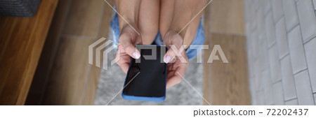 Woman holds phone in her hands having pulled down jeans on toilet in bathroom close-up Woman holds phone in her hands having pulled down jeans on toilet in bathroom close-up 72202437
