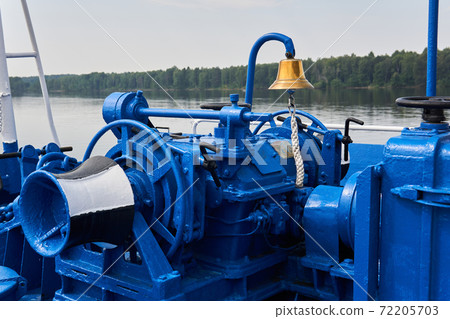 bell, capstan and other mechanisms, painted blue, on the foredeck of the river ship, close-up 72205703