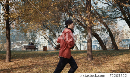 Man runner in sportswear in autumn park in the city, slow motion 72205822