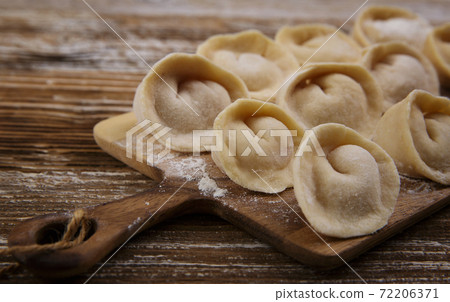wooden board for food, on which dumplings with meat are stacked 72206371