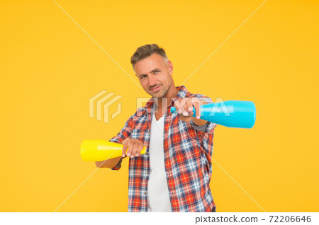 Man spraying disinfectant camera like weapon, cleaning day concept Man spraying disinfectant camera like weapon, cleaning day concept 72206646