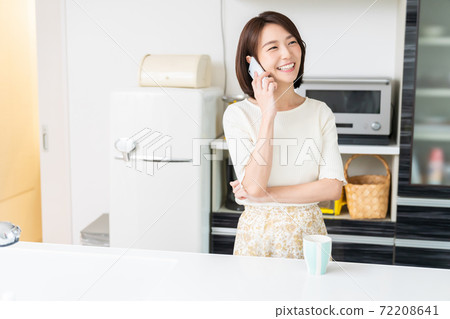 一個女人在廚房打電話 72208641