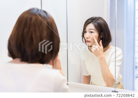 女人看著鏡子皮膚護理 72208642