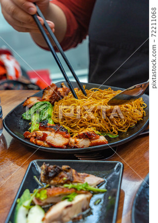 Tourist eating Singapore honey grilled pork noodles Tourist eating Singapore honey grilled pork noodles 72211068
