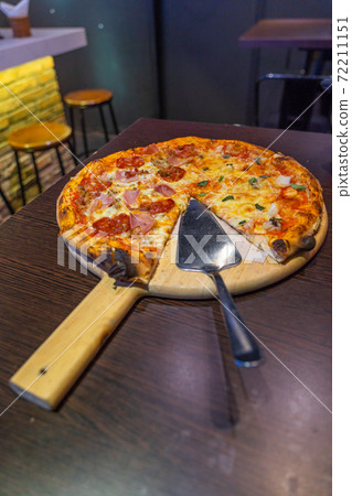Delicious Italian handmade pepperoni pizza on the table Delicious Italian handmade pepperoni pizza on the table 72211151