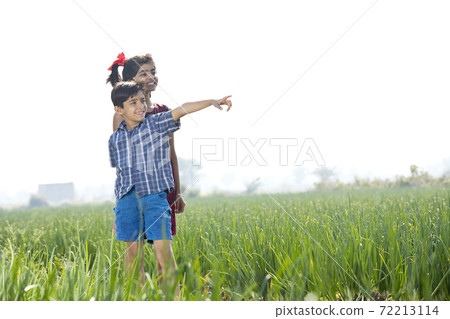 Happy children having fun in agricultural field 72213114