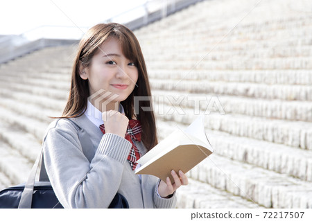 A smiling high school girl with a reference book 72217507