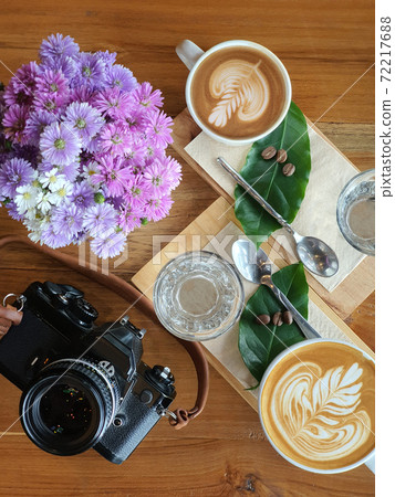 Top view of a mug of coffee with beans on wooden background. Top view of a mug of coffee with beans on wooden background. 72217688