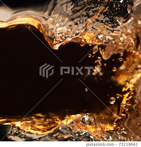 splashing of alcoholic drink on a black background 72218642