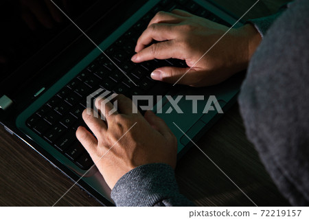 Thief hacker in mask stealing personal information from laptop 72219157