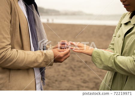 一對在沙灘上戴著戒指的情侶 一對在沙灘上戴著戒指的情侶 72219971