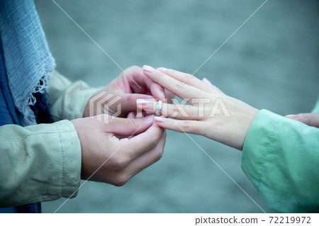 一對在沙灘上戴著戒指的情侶 一對在沙灘上戴著戒指的情侶 72219972