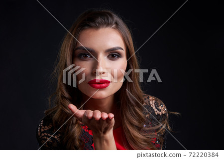 Closeup woman red lips makeup blowing a kiss at camera 72220384
