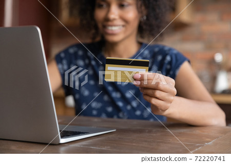 Happy millennial mixed race woman purchasing goods in internet store. Happy millennial mixed race woman purchasing goods in internet store. 72220741