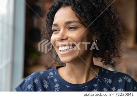 Sincere smiling young african american woman looking in distance. Sincere smiling young african american woman looking in distance. 72220841