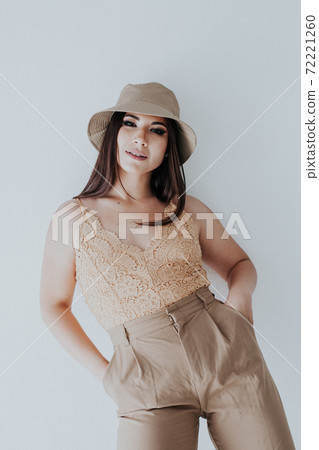 Beautiful fashionable oriental brunette woman in beige clothes Beautiful fashionable oriental brunette woman in beige clothes 72221260