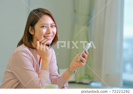 一個用智能手機開心地看著我的女人 72221292