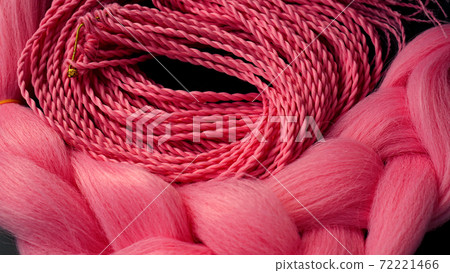Pink kanekalon hangs on a black background Pink kanekalon hangs on a black background 72221466