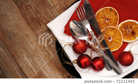 Christmas dinner decoration with dried oranges and red and white napkins Christmas dinner decoration with dried oranges and red and white napkins 72221483