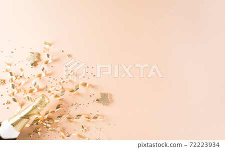 Happy New year celebration background concept. Champagne with stars and christmas ball on pastel background. Happy New year celebration background concept. Champagne with stars and christmas ball on pastel background. 72223934