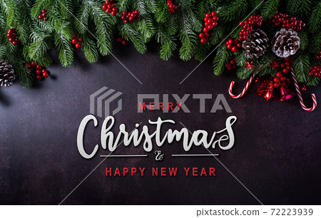 Christmas background decoration concept. Top view of red balls with spruce branches, pine cones, red berries and bell on dark stone background. Christmas background decoration concept. Top view of red balls with spruce branches, pine cones, red berries and bell on dark stone background. 72223939