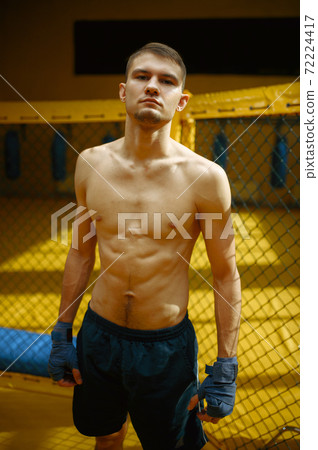 Male MMA fighter standing in a cage Male MMA fighter standing in a cage 72224417