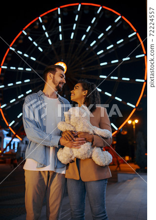 Love couple with soft toy in night amusement park Love couple with soft toy in night amusement park 72224557