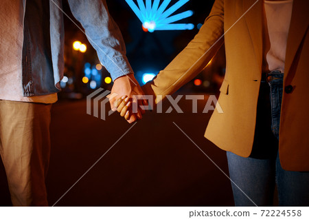 Love couple holding hands in night amusement park Love couple holding hands in night amusement park 72224558