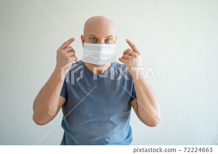 A man puts a medical mask on his face - Stock Photo [72224663] - PIXTA
