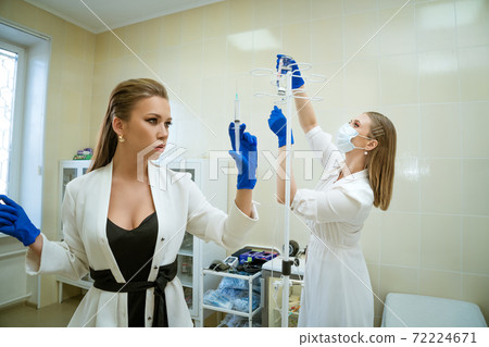 Two nurses with a syringe in their hands Two nurses with a syringe in their hands 72224671