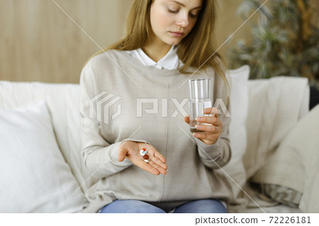 Close-up woman holding pills time to take medications, cure for headache, high blood pressure pain killer drugs at home. Stay at home concept during Coronavirus pandemic Close-up woman holding pills time to take medications, cure for headache, high blood pressure pain killer drugs at home. Stay at home concept during Coronavirus pandemic 72226181