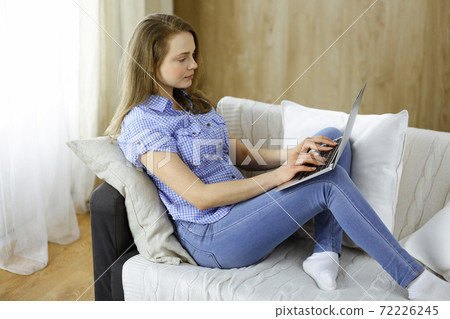 Businesswoman working on laptop computer sitting indoors during Covid-19 quarantine. Stay at home concept during Coronavirus pandemic 72226245
