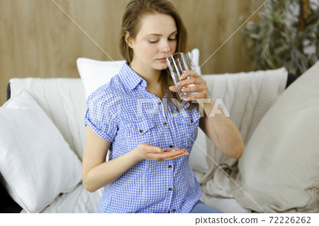 Close-up woman holding pills time to take medications, cure for headache, high blood pressure or cholesterol level remedy pain killer drugs. Medicine concept 72226262