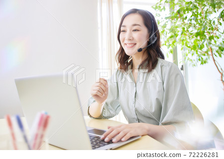 Woman having an online meeting in the living room Woman having an online meeting in the living room 72226281