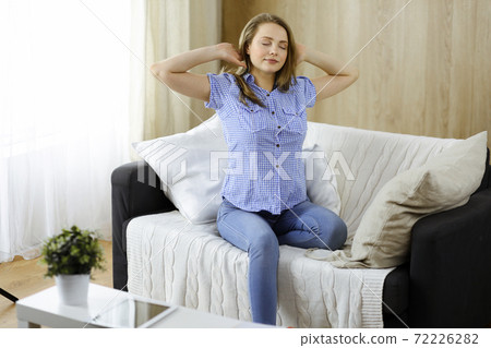 Happy blond woman put hands behind head sitting leaned on couch caucasian female enjoy lazy weekend or vacation in cozy living room, housewife relaxing feels satisfied accomplish chores housework Happy blond woman put hands behind head sitting leaned on couch caucasian female enjoy lazy weekend or vacation in cozy living room, housewife relaxing feels satisfied accomplish chores housework 72226282
