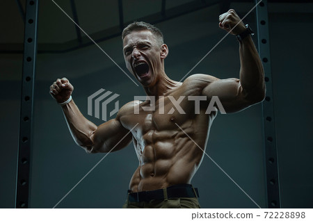 Energy caucasian strong athlete screaming in gym 72228898