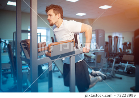 young athletic male has personal workout and pull up on bar in gym young athletic male has personal workout and pull up on bar in gym 72228999