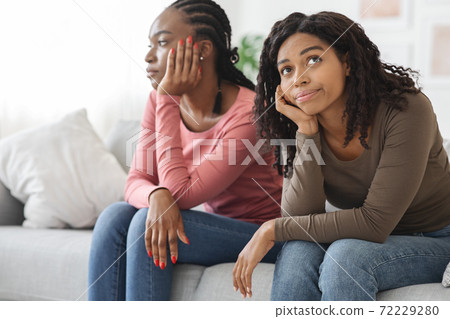 Two sad african american women sitting on sofa, had quarrel Two sad african american women sitting on sofa, had quarrel 72229280