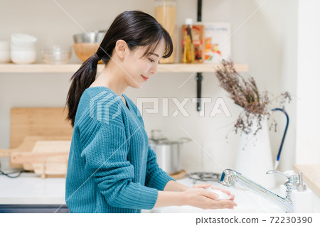 Young woman washing hands in the sink Young woman washing hands in the sink 72230390