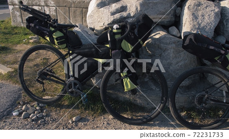 The mixed terrain cycle touring bike with bikepacking. The trip on multitrack bike, outdoor road in mountain snow capped. The mixed terrain cycle touring bike with bikepacking. The trip on multitrack bike, outdoor road in mountain snow capped. 72231733