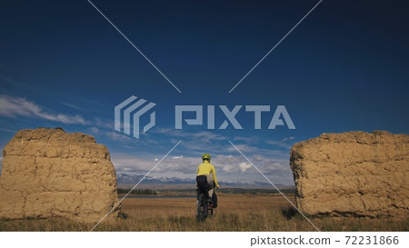 The woman travel on mixed terrain cycle touring with bikepacking. The traveler journey with bicycle bags. Sport tourism bikepacking. 72231866