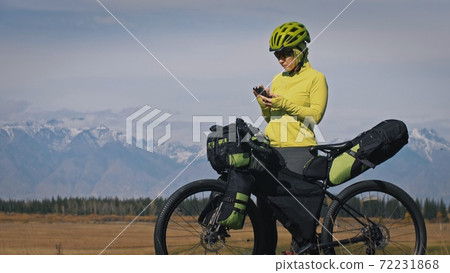 The woman travel on mixed terrain cycle touring with bikepacking. The traveler journey with bicycle bags. Sport tourism bikepacking. The woman travel on mixed terrain cycle touring with bikepacking. The traveler journey with bicycle bags. Sport tourism bikepacking. 72231868