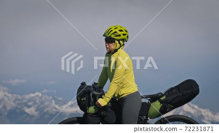 The woman travel on mixed terrain cycle touring with bikepacking. The traveler journey with bicycle bags. Sport tourism bikepacking. 72231871