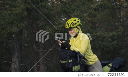 The woman travel on mixed terrain cycle touring with bike bikepacking. The traveler journey with bicycle bags. Magic forest park. The woman travel on mixed terrain cycle touring with bike bikepacking. The traveler journey with bicycle bags. Magic forest park. 72231891