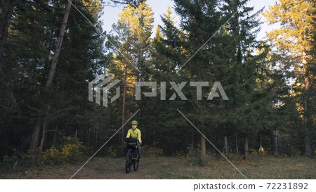 The woman travel on mixed terrain cycle touring with bike bikepacking. The traveler journey with bicycle bags. Magic forest park. The woman travel on mixed terrain cycle touring with bike bikepacking. The traveler journey with bicycle bags. Magic forest park. 72231892