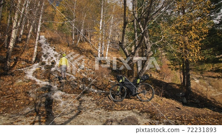 The man travel on mixed terrain cycle touring with bikepacking. The traveler journey with bicycle bags. Sport tourism bikepacking. The man travel on mixed terrain cycle touring with bikepacking. The traveler journey with bicycle bags. Sport tourism bikepacking. 72231893